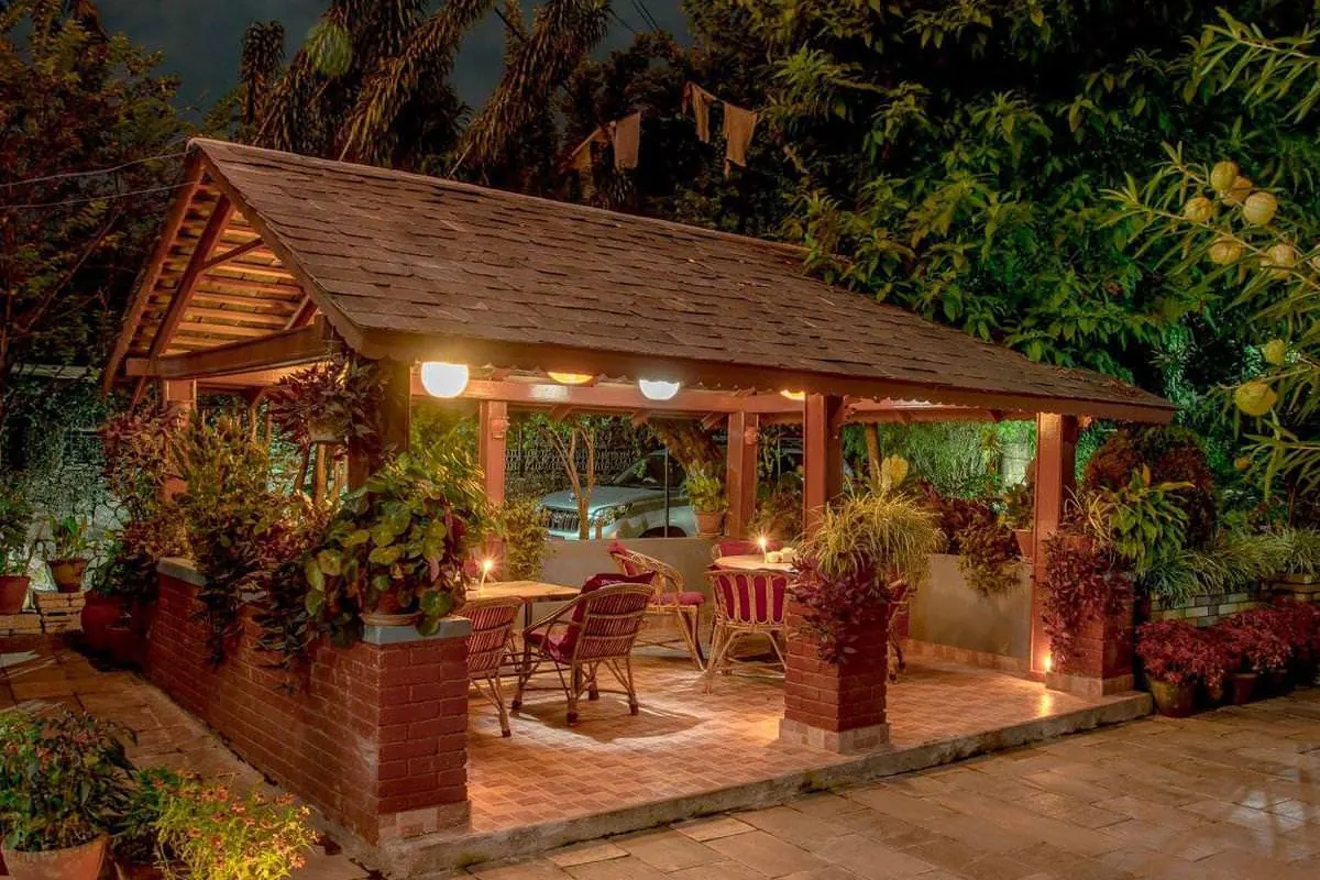 Wooden garden pavilion lit up at night at The Silver Oaks Inn, Pokhara