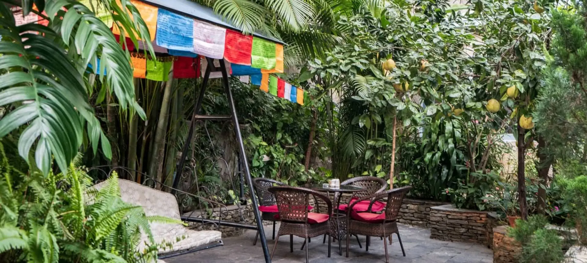 Garden swing under prayer flags at The Silver Oaks Inn, Pokhara