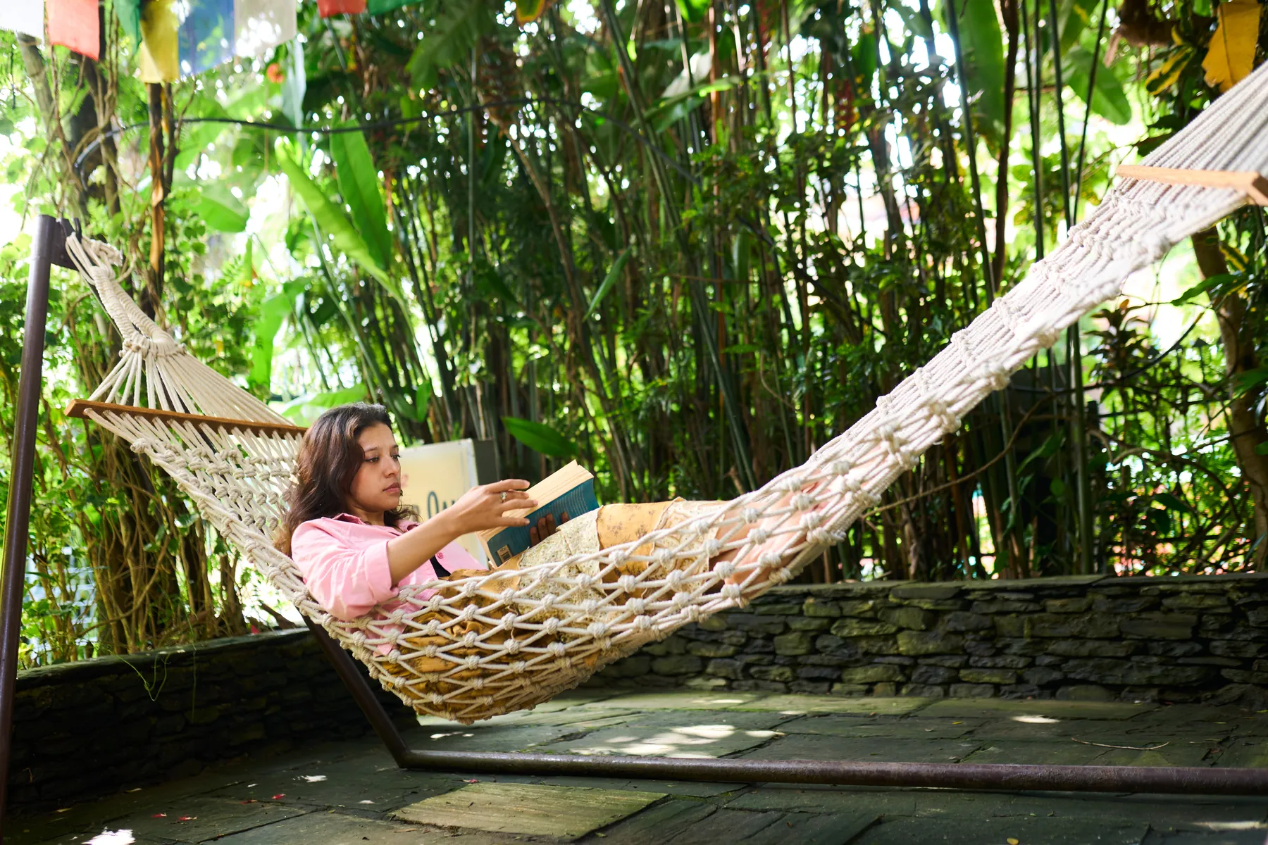 Guest reading in a hammock among the bamboo in the garden