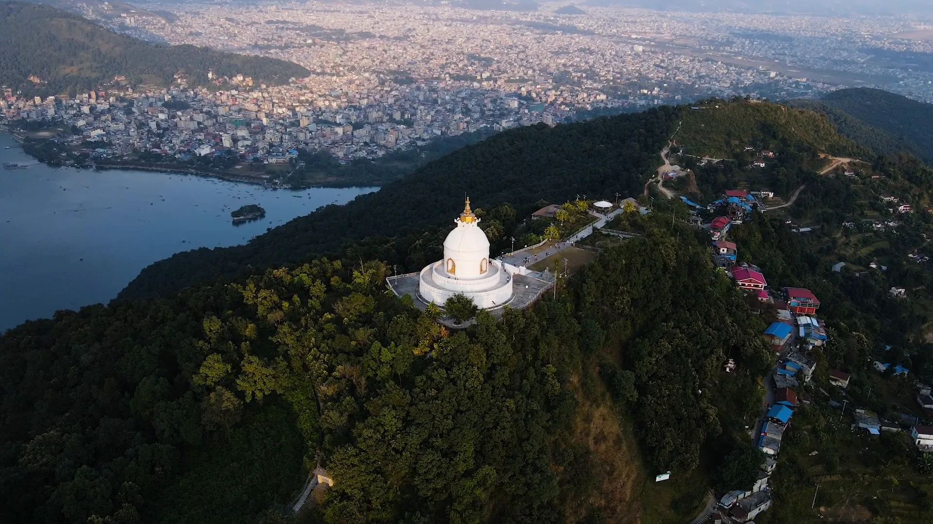 The white World Peace Pagoda on its forested ridge above Phewa Lake and Pokhara